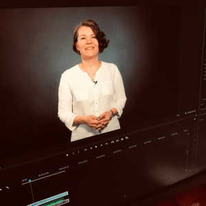 Kuva tietokoneen näytöstä. Näytöllä pysäytyskuva ruskeahiuksisesta naisesta videolla.