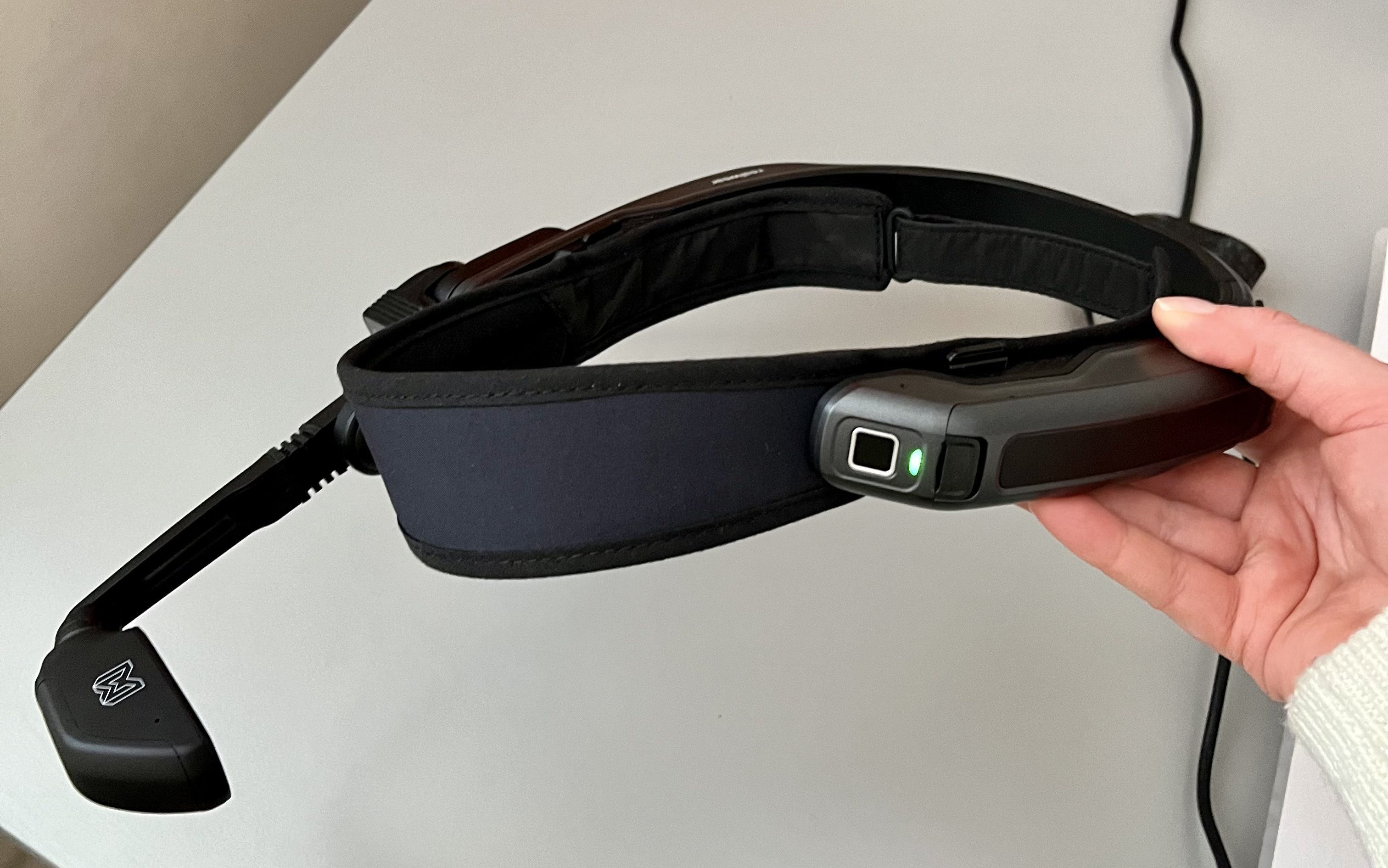 Käsi pitelee päähän laitettavaa kameraa.